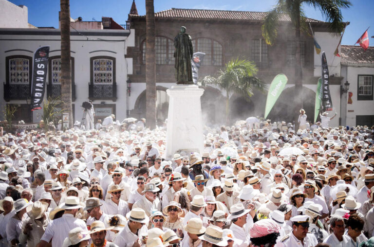 In this photo taken on Monday, Feb. 16, 2015, revellers known as 'Los Indianos' covered in talcum powder that was thrown over them take part in the carnival in Santa Cruz de la Palma in the Canary islands, Spain. 'Los Indianos' represent the return of emigrants from the Americas, who returned to the island wealthier.